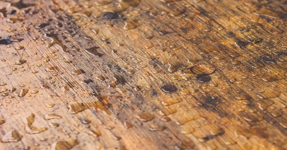 Patio en bois mouillé par la pluie avec des gouttelettes visibles sur les planches